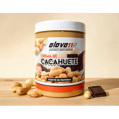 Beurre de cacahuètes Kinchoc sans sucre en pot, étiquette avec des morceaux de cacahuètes et du chocolat autour, sur bois.