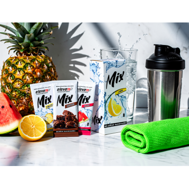 Pack de 12 sobres variados Mix de sabores con frutas y bebidas, junto a una licuadora y toalla verde.